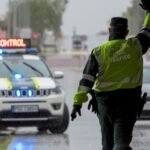 Agente de tráfico dirigiendo el control vehicular bajo la lluvia.